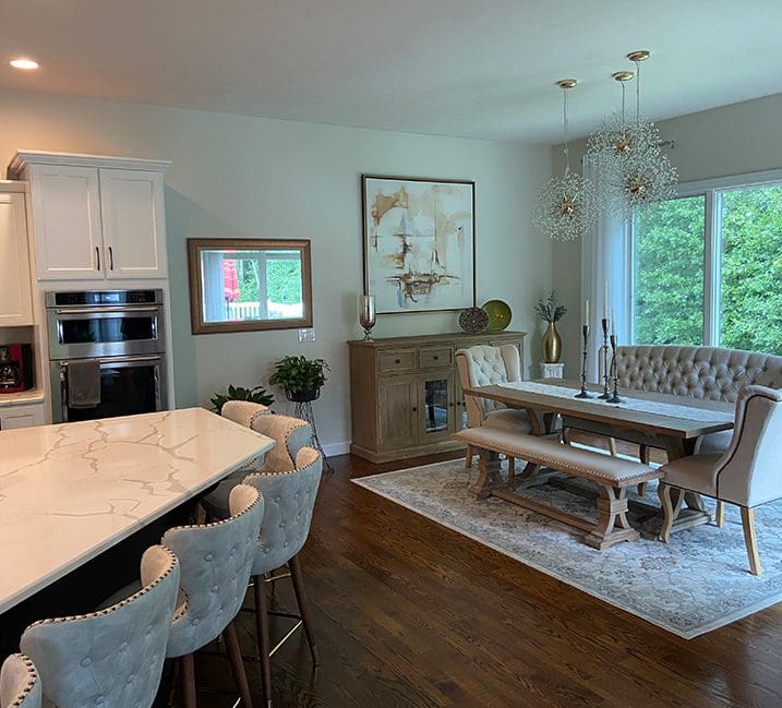 A dining room with a table and chairs, a television and a fireplace.