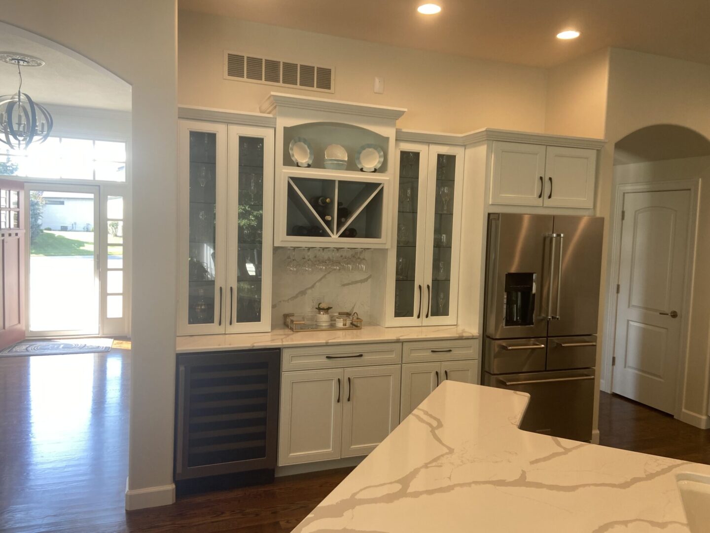 A kitchen with white cabinets and black counter tops.