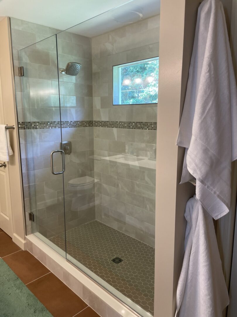 A bathroom with a shower and tiled walls.